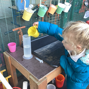 student poring water into a jug