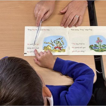 student learning how to read with the teacher