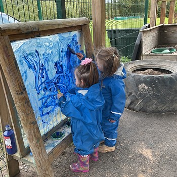 2 children painting outdoors