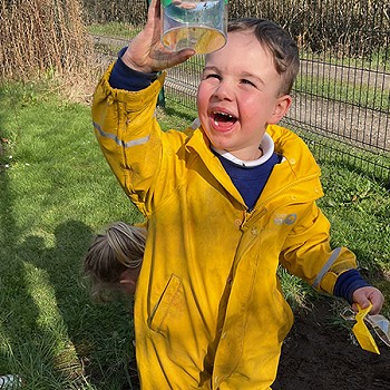 A child looking at an insect in the garden